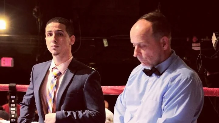 AJ Rivera stands beside a ringside official at a boxing event.