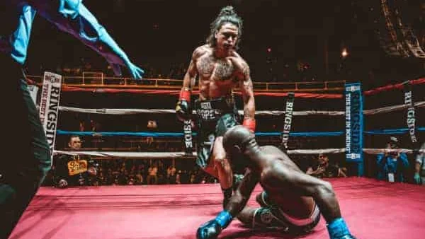 Richie Rivera stands in the boxing ring after knocking down his opponent.